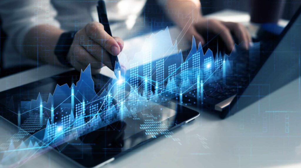 risk management strategy Image of an employee working on a laptop and tablet with 3d graphs overlayed on his devices for