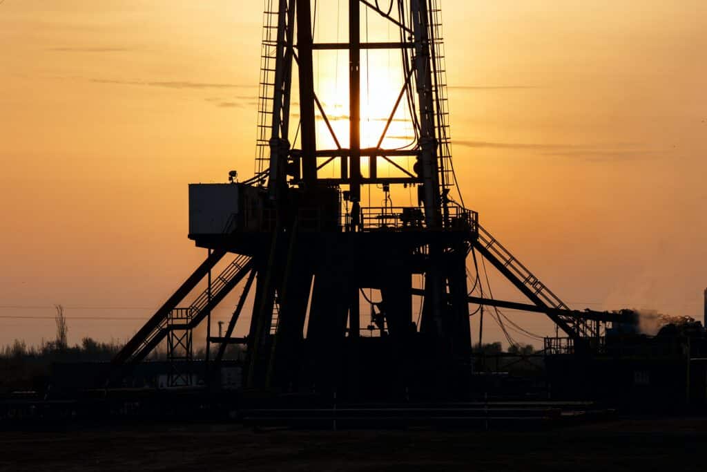 Image of a silhouette of an oil rig at sunset