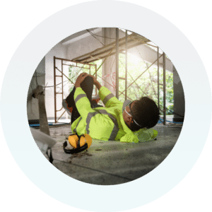 restrata-connected-resilience-duty-people-safety-security Site worker in a high visibility jacket lying on the ground stretching his leg whilst on site.